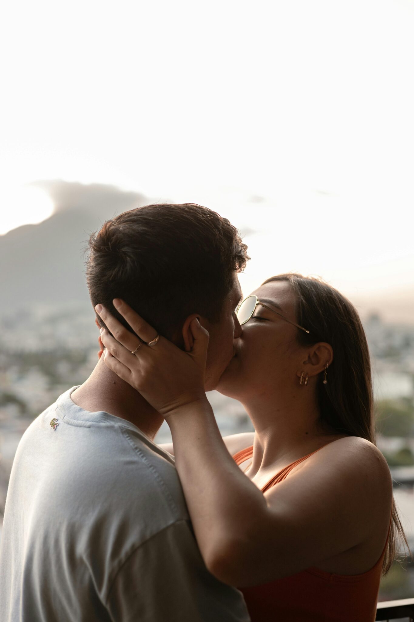 A couple shares a tender kiss during a sunset in Monterrey, Mexico, symbolizing love and intimacy.